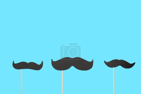 Photo for Paper mustaches on wooden sticks against color background - Royalty Free Image