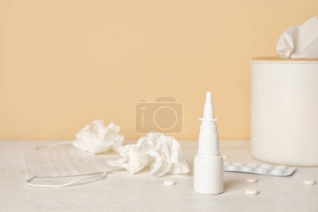 Photo for Nasal drops with pills and tissue box on table near beige wall. Allergy concept - Royalty Free Image
