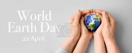 Photo for Hands of mother and child holding small planet on grey background. World Earth Day - Royalty Free Image