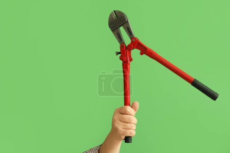 Photo for Worker with bolt cutter on green background - Royalty Free Image
