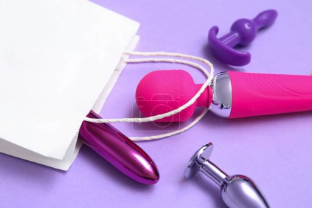Photo for Shopping bag with sex toys on lilac background, closeup - Royalty Free Image