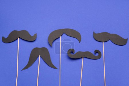 Photo for Wooden sticks with different paper mustaches on blue background - Royalty Free Image