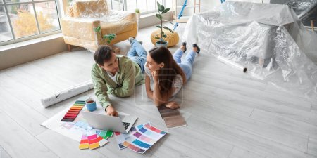 Photo for Happy young couple with laptop planning repair in their new house - Royalty Free Image