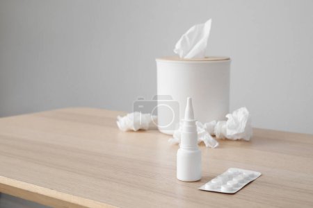 Photo for Nasal drops with pills and tissue box on table near grey wall, closeup. Allergy concept - Royalty Free Image