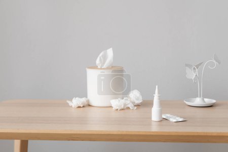 Photo for Nasal drops with pills and tissue box on table near grey wall. Allergy concept - Royalty Free Image