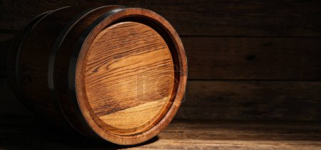 Oak barrel on wooden background with space for text