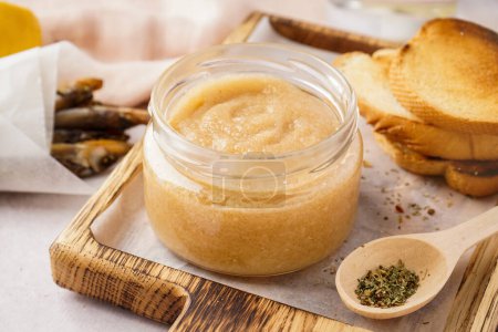 Jar with delicious caviar of capelin and fried baguette pieces on wooden board