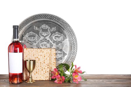 Photo for Bottle of wine, cup, Passover Seder plate, flatbread matza and alstroemeria flowers on wooden table against white background - Royalty Free Image