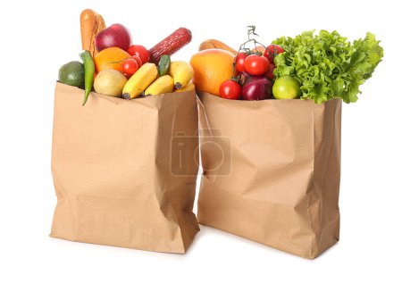 Papiertüten mit Gemüse und Obst auf weißem Hintergrund
