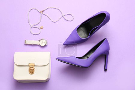 Foto de Elegantes zapatos y accesorios de tacón alto sobre fondo lila - Imagen libre de derechos