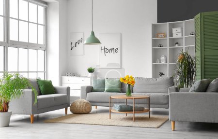 Foto de Interior de la moderna sala de estar con sofás grises y florero en la mesa de café - Imagen libre de derechos