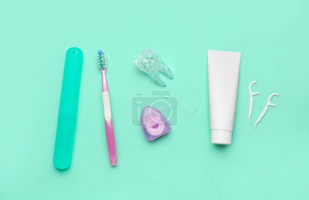 Photo for Set for oral hygiene and plastic tooth model on turquoise background - Royalty Free Image