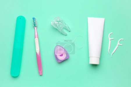 Foto de Set para higiene bucal y modelo de diente de plástico sobre fondo turquesa - Imagen libre de derechos