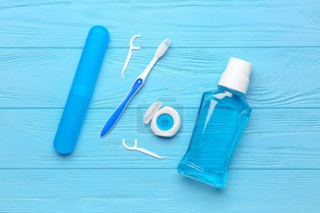 Photo for Dental floss, rinse, toothpicks and brush on blue wooden background - Royalty Free Image