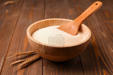Photo for Bowl with raw semolina on wooden background - Royalty Free Image