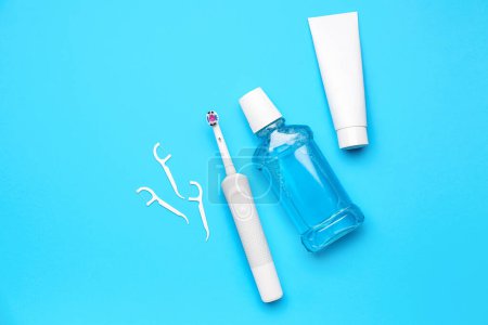 Photo for Floss toothpicks, electric brush, paste and rinse on blue background - Royalty Free Image