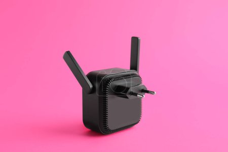 Foto de Repetidor WiFi negro sobre fondo rosa - Imagen libre de derechos