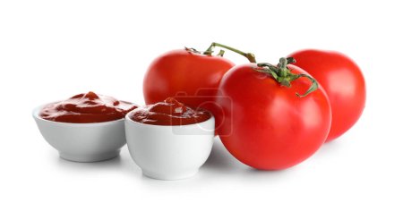 Cuencos de sabroso ketchup y tomates frescos aislados sobre fondo blanco