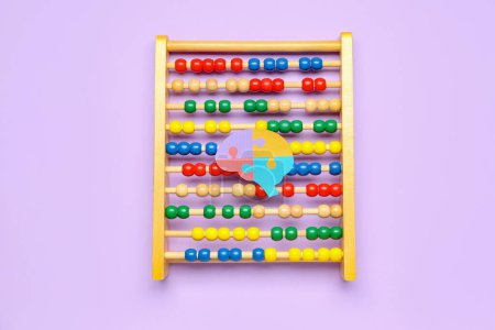 Photo for Abacus with paper brain on lilac background. World Autism Awareness Day - Royalty Free Image