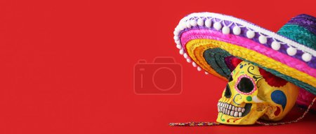 Foto de Calavera humana pintada para el Día de los Muertos de México (El Día de Muertos) y sombrero sobre fondo rojo con espacio para texto - Imagen libre de derechos