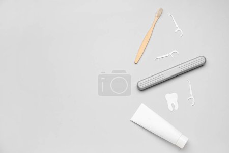 Foto de Escarbadientes, tubo de pasta, cepillo y modelo de dientes sobre fondo gris - Imagen libre de derechos
