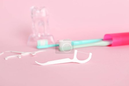 Foto de Escarbadientes, cepillos y modelo de dientes de plástico sobre fondo rosa - Imagen libre de derechos
