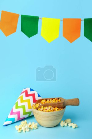 Foto de Cuenco con cucharada de maíz, sombrero de fiesta y banderas sobre fondo azul. Festa Junina (Festival de Junio) celebración - Imagen libre de derechos