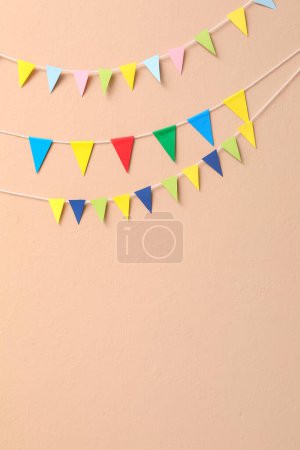 Colorful flags for Festa Junina on beige wall