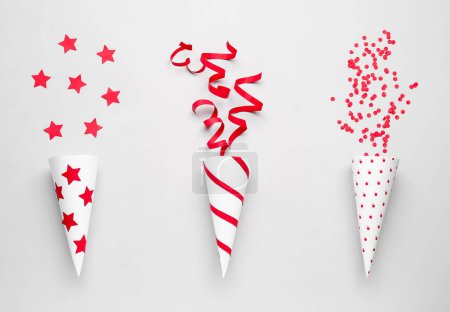 Photo for Party cones with serpentine, stars and confetti on light background - Royalty Free Image