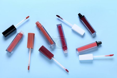Foto de Set de diferentes lápices labiales líquidos sobre fondo de color - Imagen libre de derechos