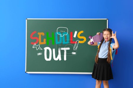 Téléchargez les photos : Petite fille avec planche à roulettes près du tableau noir avec texte SCHOOL'S OUT sur fond bleu - en image libre de droit