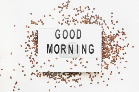 Photo for Board with text GOOD MORNING and coffee beans on light background - Royalty Free Image