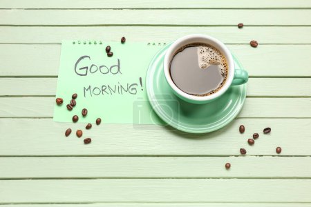 Tasse Kaffee, Bohnen und Papier mit Text GUT MORNING auf farbigem Holzhintergrund