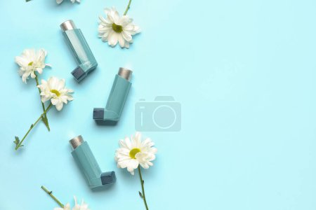Téléchargez les photos : Inhalateurs d'asthme avec des fleurs de marguerite sur fond bleu - en image libre de droit