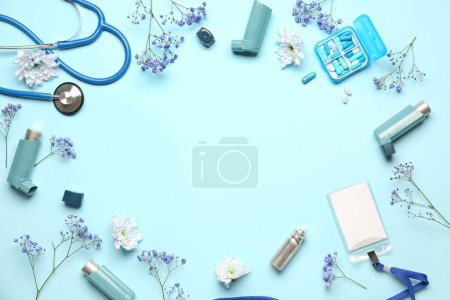 Téléchargez les photos : Cadre en inhalateurs d'asthme, fournitures médicales et fleurs sur fond bleu - en image libre de droit