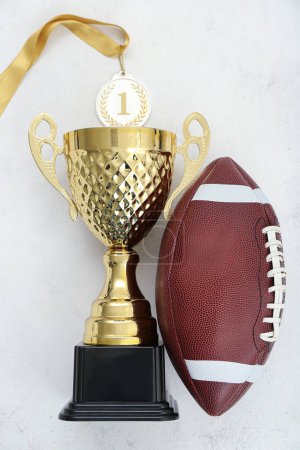 Photo for Gold cup with first place medal and rugby ball on white background - Royalty Free Image