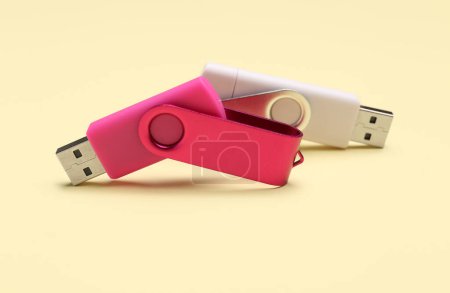Foto de Unidades flash USB rosadas y blancas sobre fondo amarillo - Imagen libre de derechos