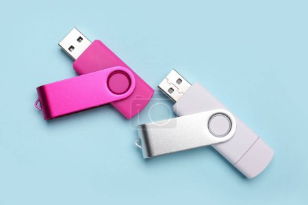 Foto de Unidades flash USB rosadas y blancas sobre fondo azul - Imagen libre de derechos