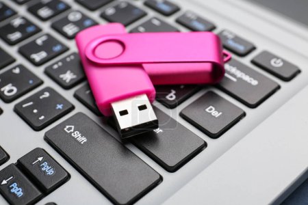 Photo for Pink USB flash drive on modern laptop, closeup - Royalty Free Image