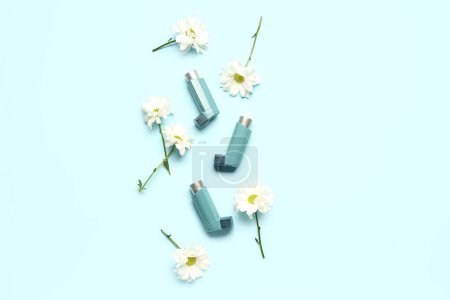 Téléchargez les photos : Inhalateurs d'asthme avec des fleurs de marguerite sur fond bleu - en image libre de droit