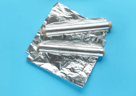 Aluminiumfolien Rollen und Blech auf farbigem Hintergrund
