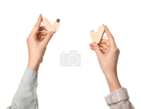 Foto de Manos femeninas sosteniendo unidades flash USB de madera aisladas sobre fondo blanco - Imagen libre de derechos