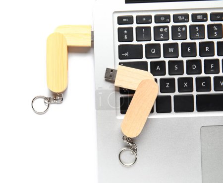 Foto de Portátil moderno con memorias USB de madera aisladas sobre fondo blanco - Imagen libre de derechos
