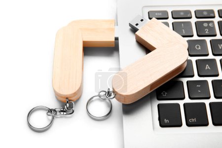 Foto de Portátil moderno con memorias USB de madera aisladas sobre fondo blanco - Imagen libre de derechos