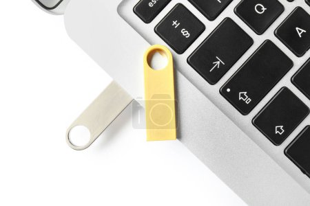 Foto de Portátil moderno con unidades flash USB metálicas y doradas aisladas sobre fondo blanco - Imagen libre de derechos