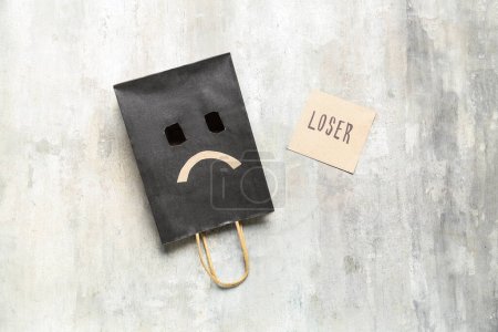 Photo for Paper bag with sad smile and word LOSER on grunge background - Royalty Free Image