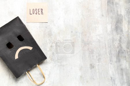 Photo for Paper bag with sad smile and word LOSER on grunge background - Royalty Free Image