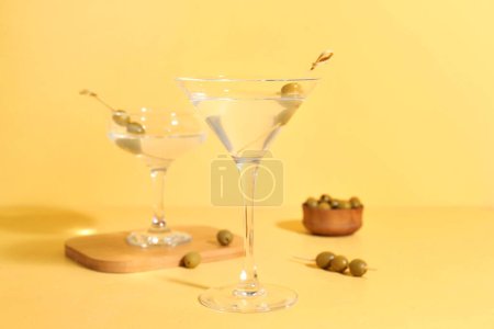 Photo for Glasses of martini with olives on yellow background - Royalty Free Image