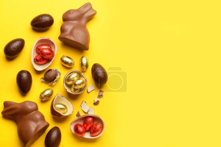 Photo for Chocolate Easter eggs and bunnies on yellow background - Royalty Free Image