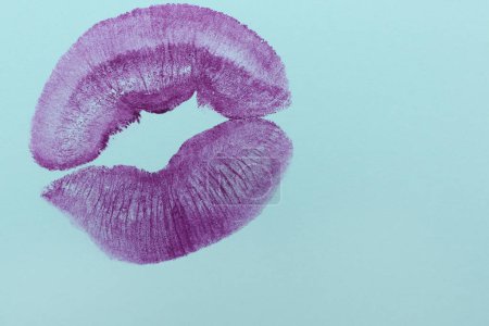 Téléchargez les photos : Rouge à lèvres violet baiser marque sur fond bleu - en image libre de droit